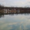 Smooth lake with houses and trees as seen from opposite shore