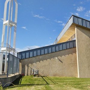 Side view of prison wall with tower and multistory building with curved wall and roof