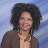 African-American woman smiling with long curly hair and necklace