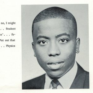 Young African-American man in suit and tie with text in yearbook