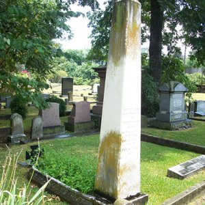 Weathered obelisk shaped gravestone in cemetery