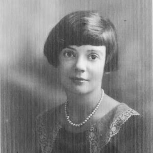 Young white girl smiling in dress with pearl necklace