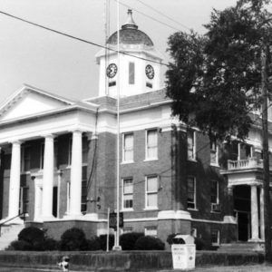 Multistory brick building with classical entrance clock tower with dome side balcony and street corner