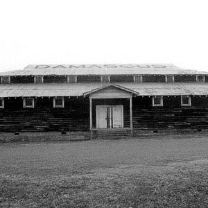 Front view of multistory building with covered porch and "Damascus" on its roof