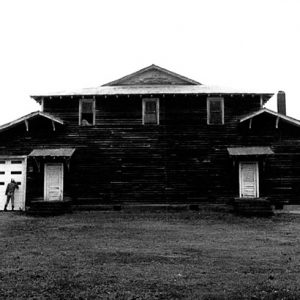 Side view of building with two doors under awnings and man standing at garage door