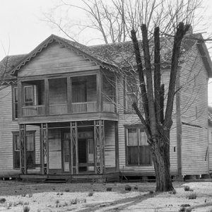 Two-story house with covered porch and bare trees