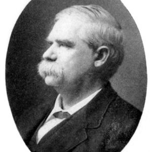 Profile view of old white man with mustache in suit and tie