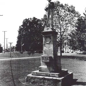 Statue of soldier with gun on stone monument with pedestal