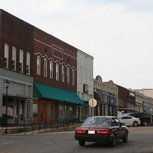 Multistory brick storefront buildings with sidewalk on street