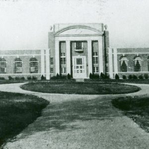 Multistory building with single-story wings and circular driveway