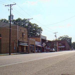 Street with brick storefronts and street signs on both sides