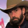 White man with long hair and beard in cowboy hat