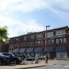 Three-story brick building on street corner with parking lot