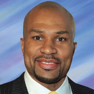 African-American man with mustache and beard smiling in suit