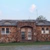 Stone building with arched entrance and two front doors