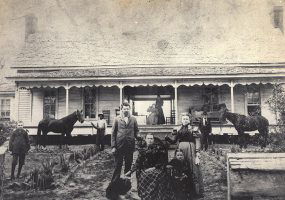 White family and animals outside single-story house