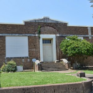 Brick building with covered window and steps leading to entrance