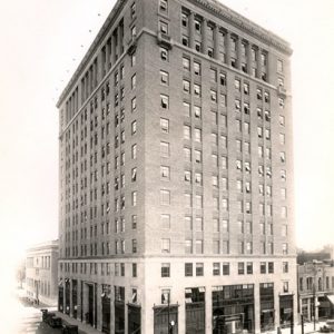 Tall corner building on street with parked cars