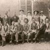 Group of white men in Masonic garb outside brick building