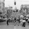 busy city intersection with cars and people, view of state capitol in background