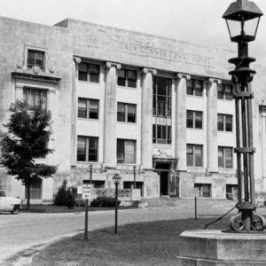 Four-story stone building with circle driveway and parked cars