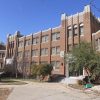 Three-story brick school building with steps and courtyard