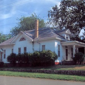 Side view of house with white siding and covered porch on street