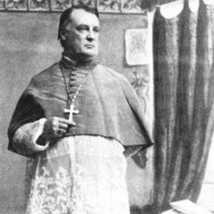 White man in bishop's robes with cross necklace