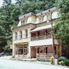 Three-story brick building with covered porch and balcony and parking lot with car