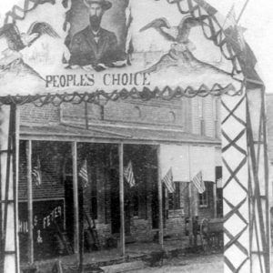 Arch with photograph of a white man in a cowboy hat inscribed with the words "People's Choice"