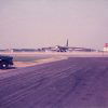 Large airplane on airstrip with truck in foreground