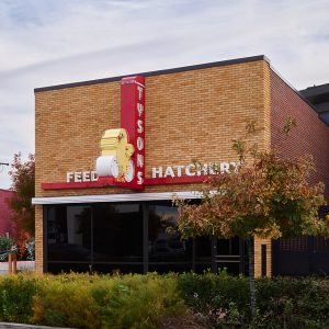 Brick storefront with neon "Tyson's feed hatchery" sign