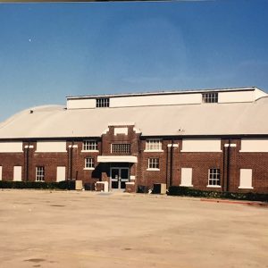 Brick gymnasium building with rounded roof and skylight