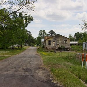 road with signs and mobile home and run-down houses on right side