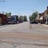 Street with brick buildings parked cars and water tower