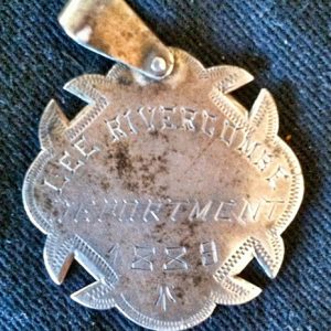 "Lee Rivercomee Deportment 1889" metal badge