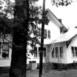 Rear view of multistory house with trees in the foreground