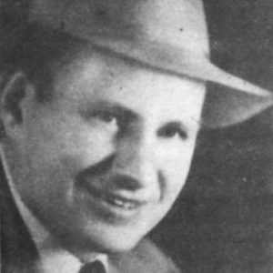 White man smiling in hat and suit