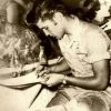 Young white man with rolled up shirt sleeves signing paper at bar