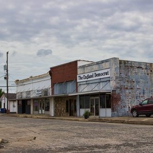 Weathered brick storefronts with awnings on street