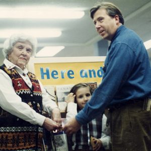 Old white woman with white man and girl in library