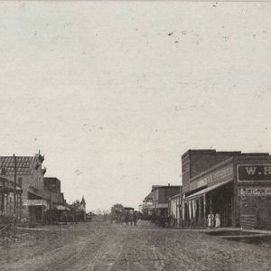 Single and multistory storefront buildings with signs on town street