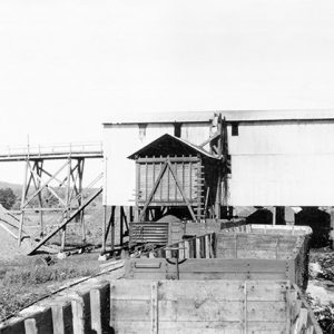 Two-story mining building with carts and machinery