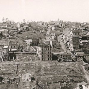 View of town with multistory buildings on dirt roads