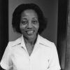 African-American woman smiling in collared white shirt