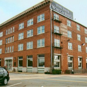 Multistory brick building and parking lot on street corner