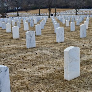 Rows of white marble grave markers in cemetery