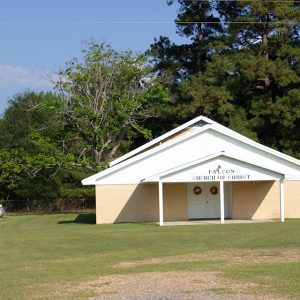 Single-story building with covered entrance and double doors on grass