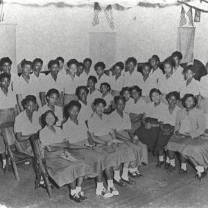 African-American girls in matching dresses in classroom with teacher