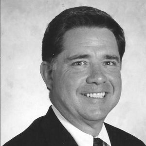 White man smiling in suit and tie